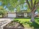 Charming two-story home featuring a manicured lawn, gray brick facade, and inviting white front door at 6684 S Buffalo Dr, Littleton, CO 80120