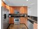Modern kitchen featuring stainless steel appliances, granite counters, and wooden cabinets at 6684 S Buffalo Dr, Littleton, CO 80120