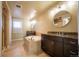 Bright bathroom featuring an oval soaking tub, elegant fixtures and dark wood cabinets at 1970 Woodbourne Ter, Castle Rock, CO 80104