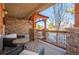 Cozy covered porch featuring stone accents, wood railings, and comfortable outdoor seating at 1970 Woodbourne Ter, Castle Rock, CO 80104