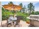 Outdoor deck with a dining set, umbrella, grill, and green foliage views at 1970 Woodbourne Ter, Castle Rock, CO 80104