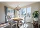 Bright dining area with a round wooden table, white chairs, and large windows with a view at 1970 Woodbourne Ter, Castle Rock, CO 80104