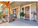 Inviting front porch with stone pillars, stylish decor, and comfortable seating area at 1970 Woodbourne Ter, Castle Rock, CO 80104