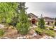 Landscaped front yard with a variety of trees, shrubs, and decorative rocks, providing a natural setting at 1970 Woodbourne Ter, Castle Rock, CO 80104