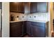 Kitchenette with granite countertops, dark wood cabinets, and tile backsplash at 1970 Woodbourne Ter, Castle Rock, CO 80104