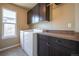 Well-equipped laundry room with washer, dryer, dark wood cabinets and counter space at 1970 Woodbourne Ter, Castle Rock, CO 80104