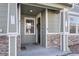 This is the entryway, which features stone accents, a covered entry, and a door with wreath at 17148 Waterhouse Cir # A, Parker, CO 80134