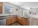 Modern kitchen featuring a peninsula island, stainless steel sink, and large windows for natural light at 17148 Waterhouse Cir # A, Parker, CO 80134