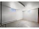 Unfinished basement with small windows, concrete floor, and white walls at 2704 S Ames Way, Denver, CO 80227