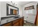 Bathroom with a dark vanity, a shower behind the curtain, and window at 2704 S Ames Way, Denver, CO 80227