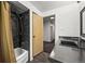 Bathroom with a tiled shower behind the curtain, and dark vanity at 2704 S Ames Way, Denver, CO 80227