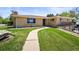 Inviting single-story home featuring a lush green lawn and curved walkway to the front door at 2704 S Ames Way, Denver, CO 80227