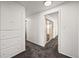 Hallway with storage cabinets, gray carpet, neutral paint and an open doorway at 2704 S Ames Way, Denver, CO 80227