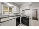 Efficient kitchen featuring white cabinets, updated appliances, and durable tile flooring for easy maintenance at 2704 S Ames Way, Denver, CO 80227