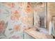 Charming powder room featuring floral wallpaper, stylish mirror, and granite countertop at 5101 Meade St, Denver, CO 80221