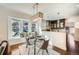 Cozy dining area with a glass table, window seating, and pendant lighting at 5101 Meade St, Denver, CO 80221