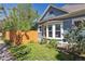 Charming blue home exterior with a fenced yard, flower garden and lush green lawn at 5101 Meade St, Denver, CO 80221