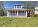 Inviting two-story home featuring a charming front porch and well-manicured lawn at 5101 Meade St, Denver, CO 80221