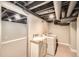 Basement laundry room with white subway tile, open ceilings and updated appliances at 5101 Meade St, Denver, CO 80221