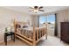 Bright bedroom featuring wood bed frame, a ceiling fan and two windows overlooking the neighborhood at 11975 Riverstone Cir # 9E, Henderson, CO 80640