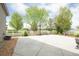 Backyard with basketball court, gravel area, lush trees, and privacy fence at 1510 S De Gaulle Cir, Aurora, CO 80018