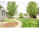 Green backyard with artificial putting green, a manicured lawn and storage sheds at 1510 S De Gaulle Cir, Aurora, CO 80018