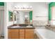Bright bathroom featuring a double vanity sink, soaking tub, and a large mirror over the vanity at 1510 S De Gaulle Cir, Aurora, CO 80018