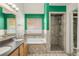 Primary bathroom featuring double sinks, a soaking tub, tiled walls and floors, and a glass-enclosed shower at 1510 S De Gaulle Cir, Aurora, CO 80018