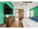 Bedroom with an accent wall, ceiling fan, barn door leading to the en suite and matching wood furniture at 1510 S De Gaulle Cir, Aurora, CO 80018