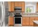 Well-lit kitchen with stainless steel appliances and light wood cabinets at 1510 S De Gaulle Cir, Aurora, CO 80018