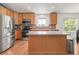 Bright kitchen featuring stainless steel appliances, light wood cabinets, and a functional island at 1510 S De Gaulle Cir, Aurora, CO 80018