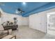 Basement living room featuring a blue ceiling, and space for multiple seating and workspace areas at 1510 S De Gaulle Cir, Aurora, CO 80018