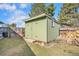 View of backyard shed with double doors and small window in the lush green yard under a clear blue sky at 2208 Champlain Dr, Boulder, CO 80301