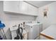 Bright laundry room equipped with a washer, dryer, utility sink, and ample storage cabinets at 2208 Champlain Dr, Boulder, CO 80301