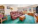 Bright living room featuring a green carpet, red sofa, and natural light at 2208 Champlain Dr, Boulder, CO 80301