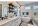 Luxurious bathroom featuring a soaking tub, dual vanity, and modern fixtures with stylish shelving at 3261 S Sherman St, Englewood, CO 80113