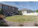 Large backyard with lush green grass, patio furniture, and well-maintained landscaping at 6185 Saddle Bow Ave, Parker, CO 80134