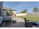 Backyard patio features outdoor seating, grill, and lush green space, ideal for relaxation and entertaining at 6185 Saddle Bow Ave, Parker, CO 80134