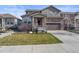 Charming two-story home featuring a stone facade, a well-manicured lawn, and a welcoming front porch at 6185 Saddle Bow Ave, Parker, CO 80134