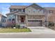 Charming two-story home featuring a stone facade and a welcoming front porch with a red door at 6185 Saddle Bow Ave, Parker, CO 80134