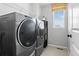 Functional laundry room featuring modern washer and dryer, shelving, and window at 6185 Saddle Bow Ave, Parker, CO 80134