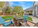 Landscaped backyard with a fire pit surrounded by Adirondack chairs, ideal for outdoor gatherings at 4235 Lark Sparrow St, Highlands Ranch, CO 80126