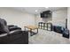 Basement entertainment area with a mounted television, storage shelves, and a rustic wooden coffee table at 4235 Lark Sparrow St, Highlands Ranch, CO 80126