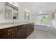 Bright bathroom featuring double vanity, soaking tub, and large window with natural light at 4235 Lark Sparrow St, Highlands Ranch, CO 80126