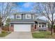 Inviting two-story home with a wide driveway and a cozy front porch, complemented by lush landscaping at 4235 Lark Sparrow St, Highlands Ranch, CO 80126