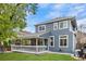 Back of house features a covered patio, backyard, and well-maintained lawn with blue siding at 4235 Lark Sparrow St, Highlands Ranch, CO 80126