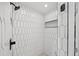 Modern shower with floor-to-ceiling geometric tiles and a sleek black showerhead at 4235 Lark Sparrow St, Highlands Ranch, CO 80126