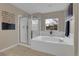 Bright bathroom with a large soaking tub, glass-enclosed shower, and neutral color palette at 4961 Aspen Creek Dr, Broomfield, CO 80023