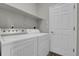 Functional laundry room with a washer, dryer, shelving, and tile flooring at 4961 Aspen Creek Dr, Broomfield, CO 80023