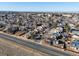 Expansive aerial view of a suburban neighborhood with tidy homes and tree-lined streets under a clear blue sky at 17990 E Cornell Dr, Aurora, CO 80013